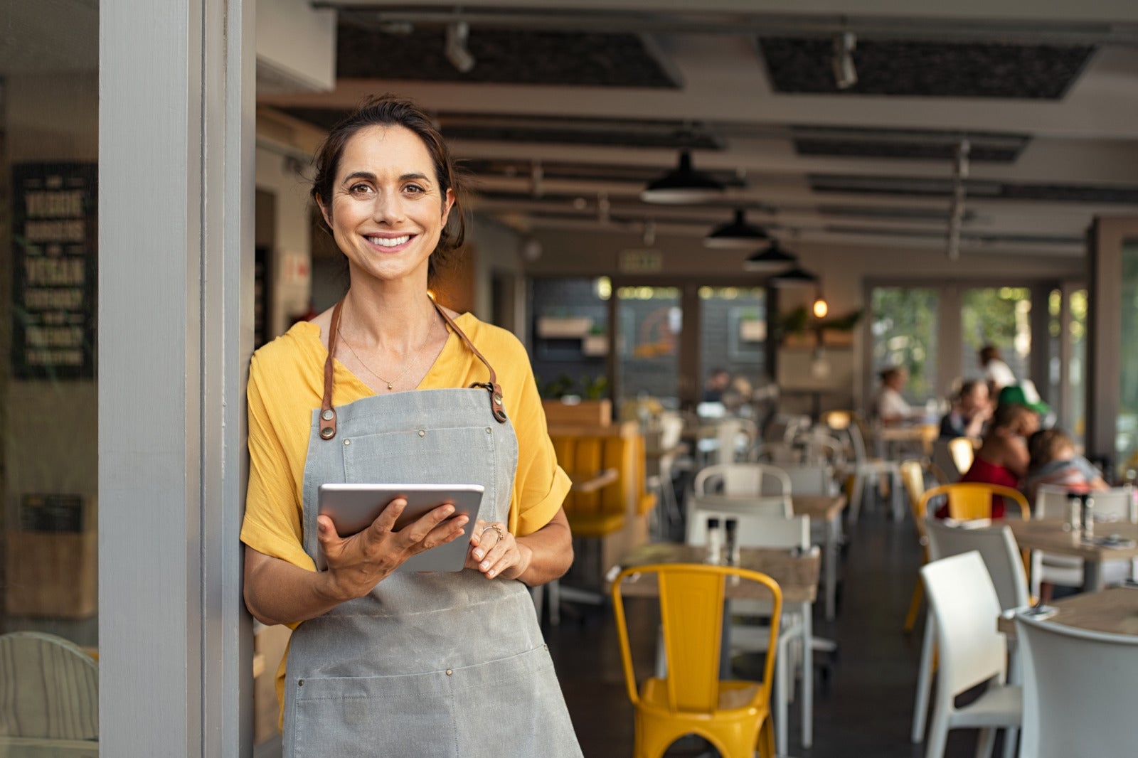 Small business owner at entrance looking at camera help smbs source top talent