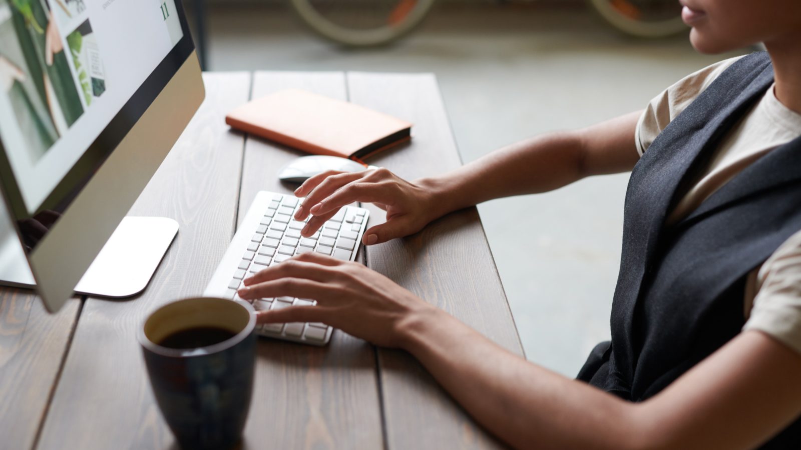 A candidate looking up employer information on social media, sitting at a desk with a coffee