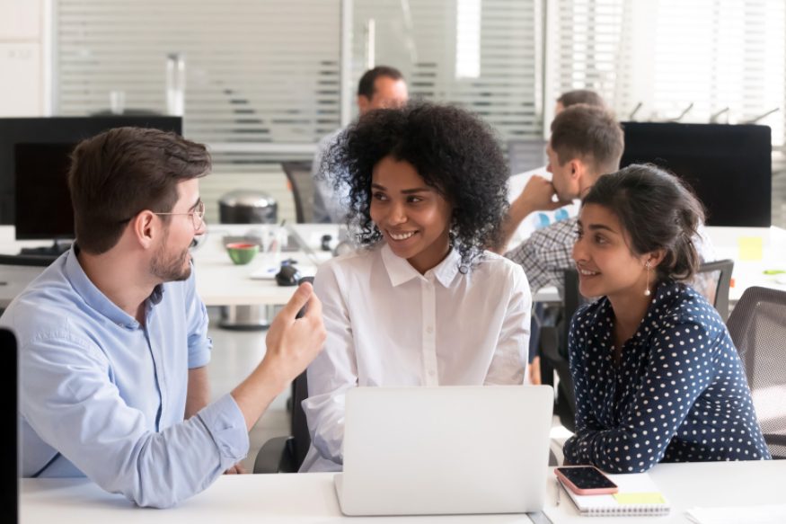 Three millennial employees working together in an office