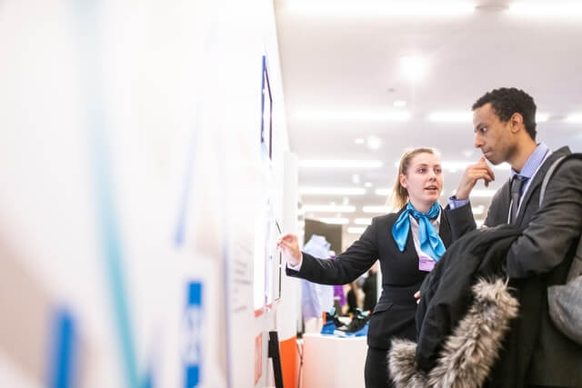 two people looking at a jobs board at a careers fair