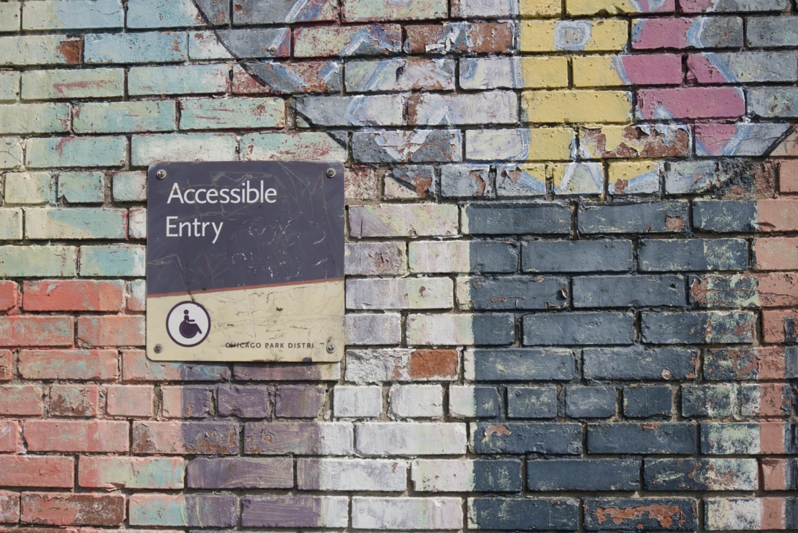 A sign on a brick wall reading 'Accessible Entry'