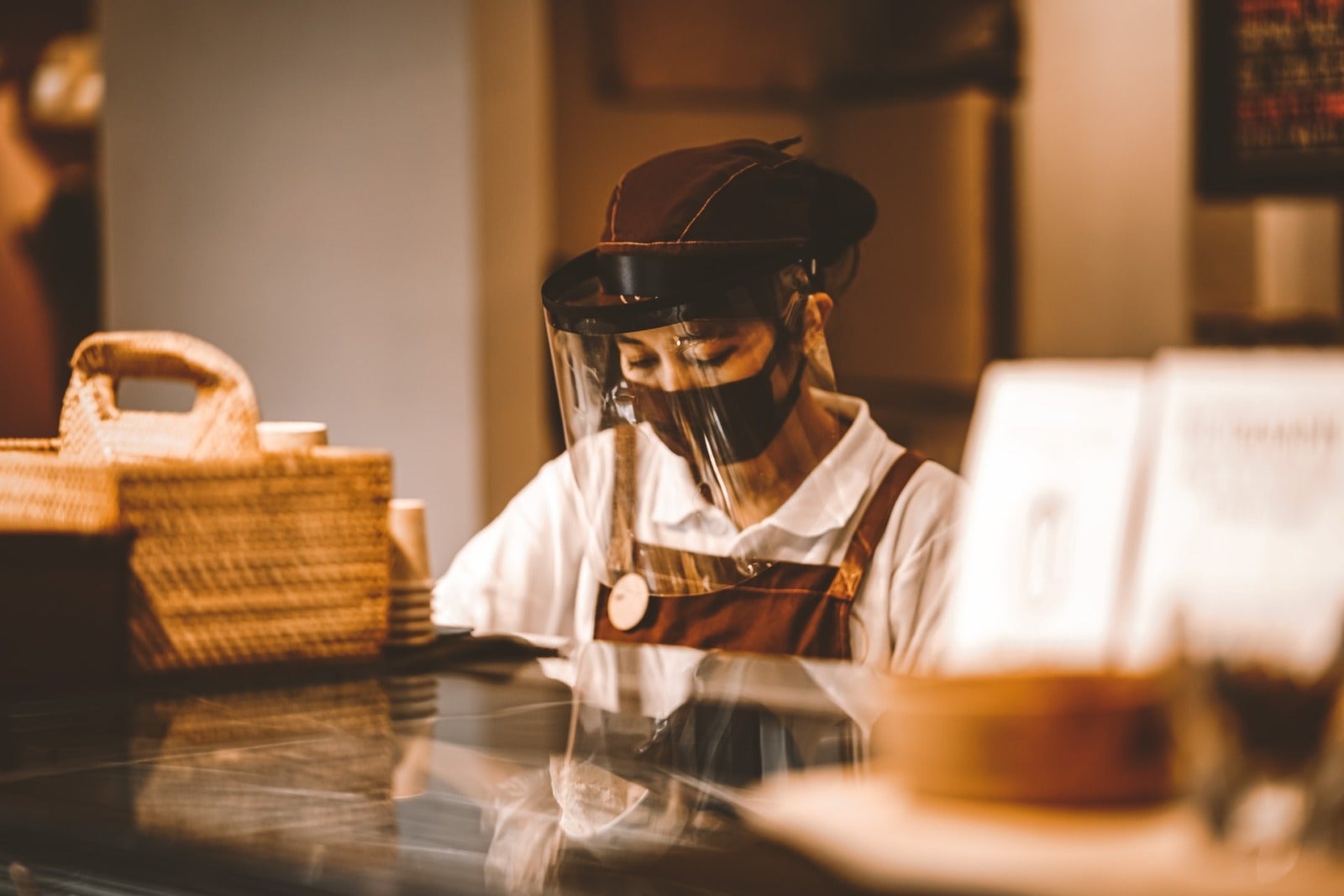 Hospitality staff - person working in a cafe with a mask and visor