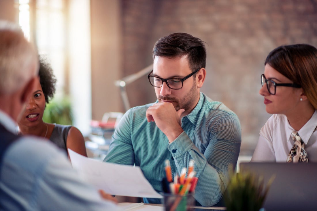 Business Meeting with Team Member Studying Document