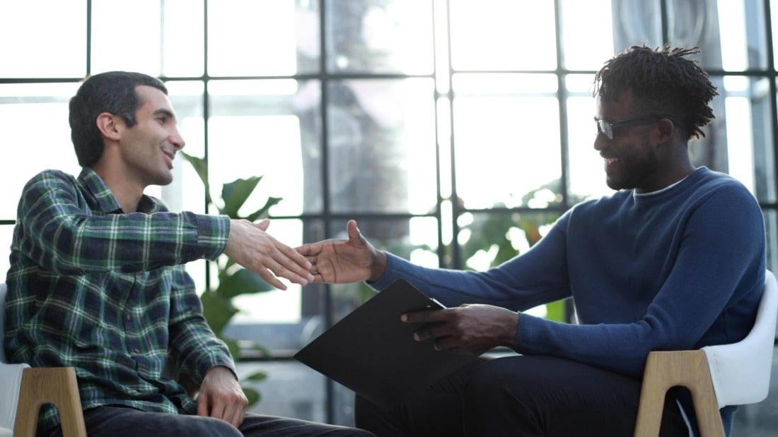 Candidate and Hiring Manager in a Relaxed Interview Setting About to Shake Hands