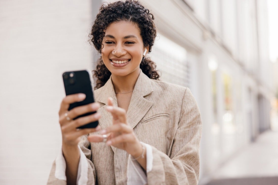 Young professional woman smiling at smartphone
