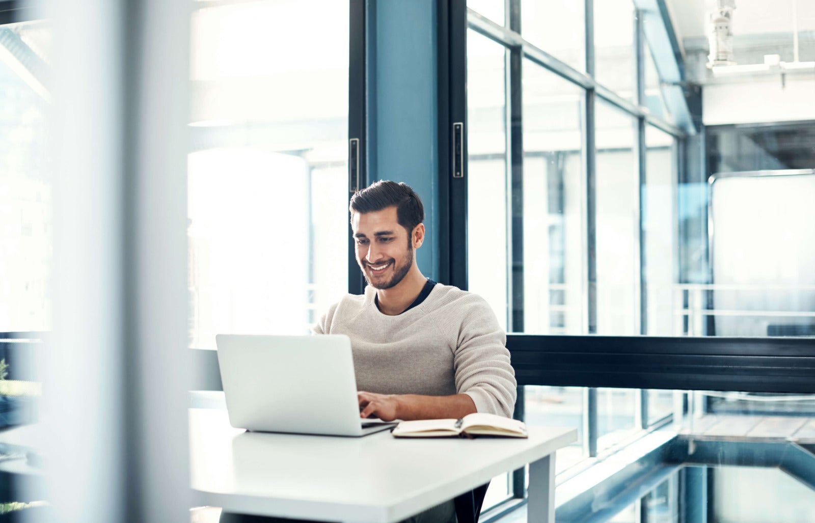 smiling business man works on laptop in sleek office space