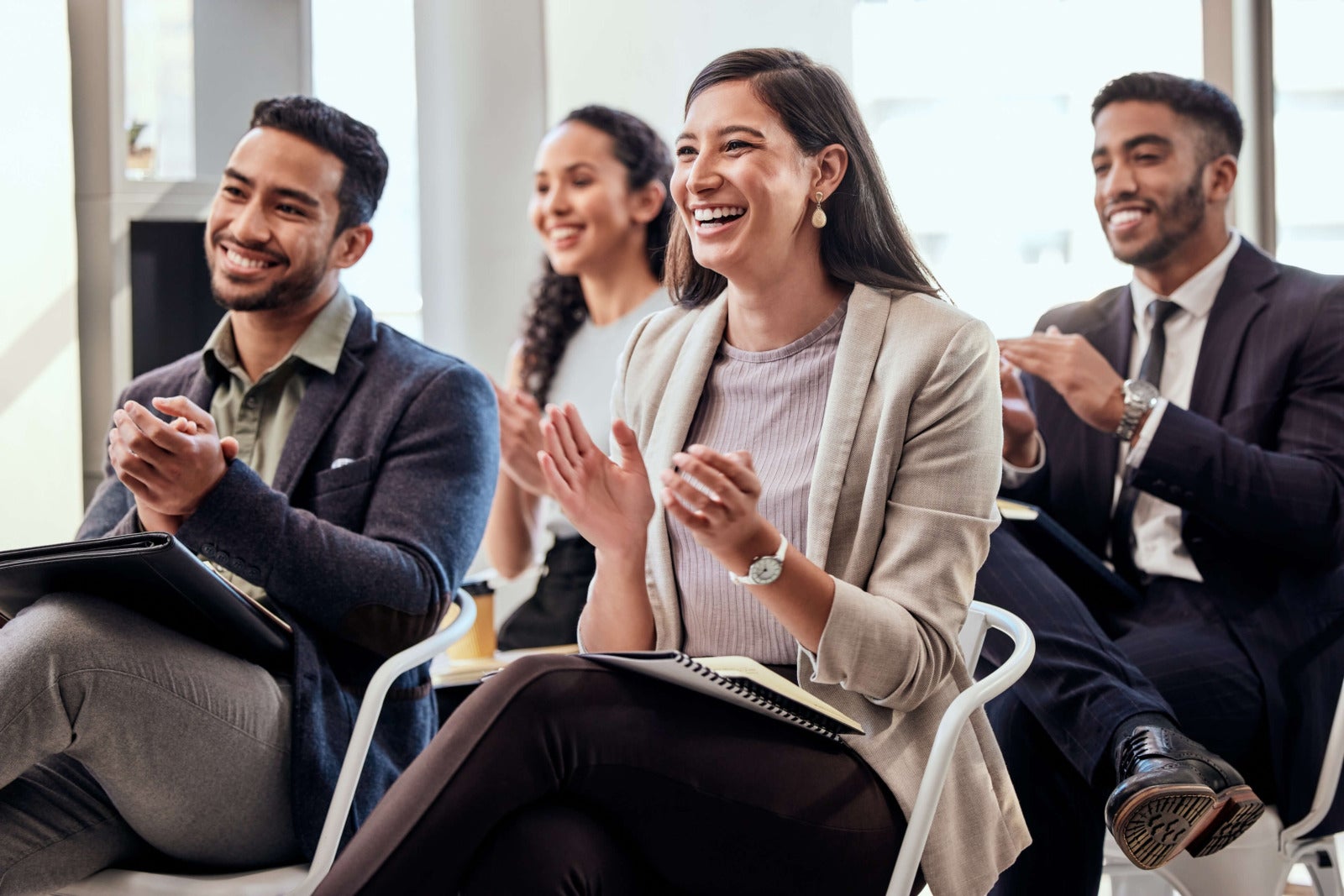 group of employees clapping to celebrate work achievement