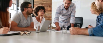 young business leader presents in front of employees