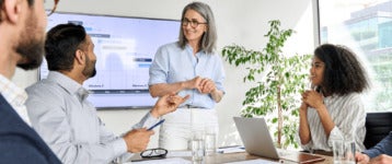 business leader presents slideshow to team in conference room