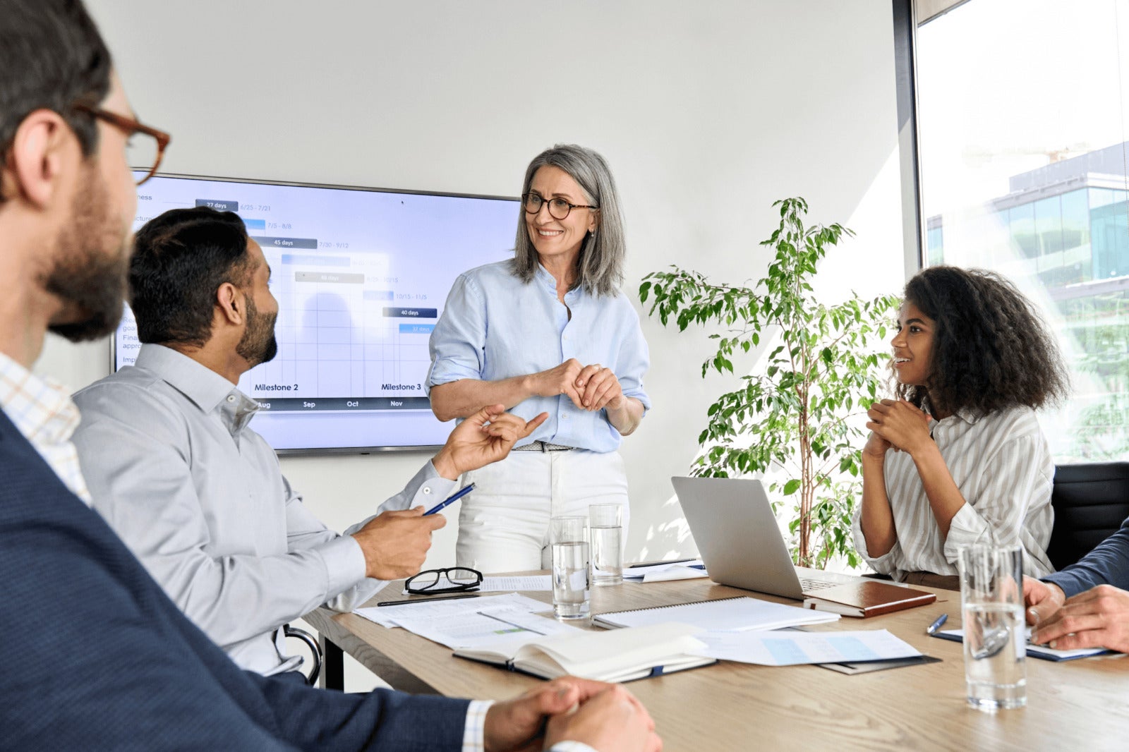 business leader presents slideshow to team in conference room