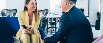 senior business leader discusses work with employee at office lounge area