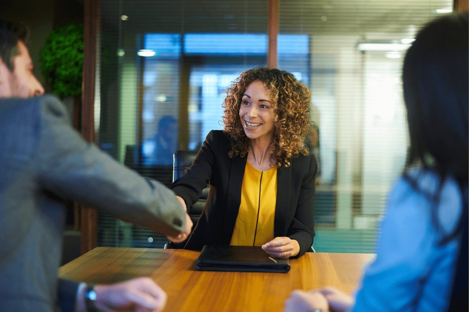 smiling job candidate shakes hands with hiring manager