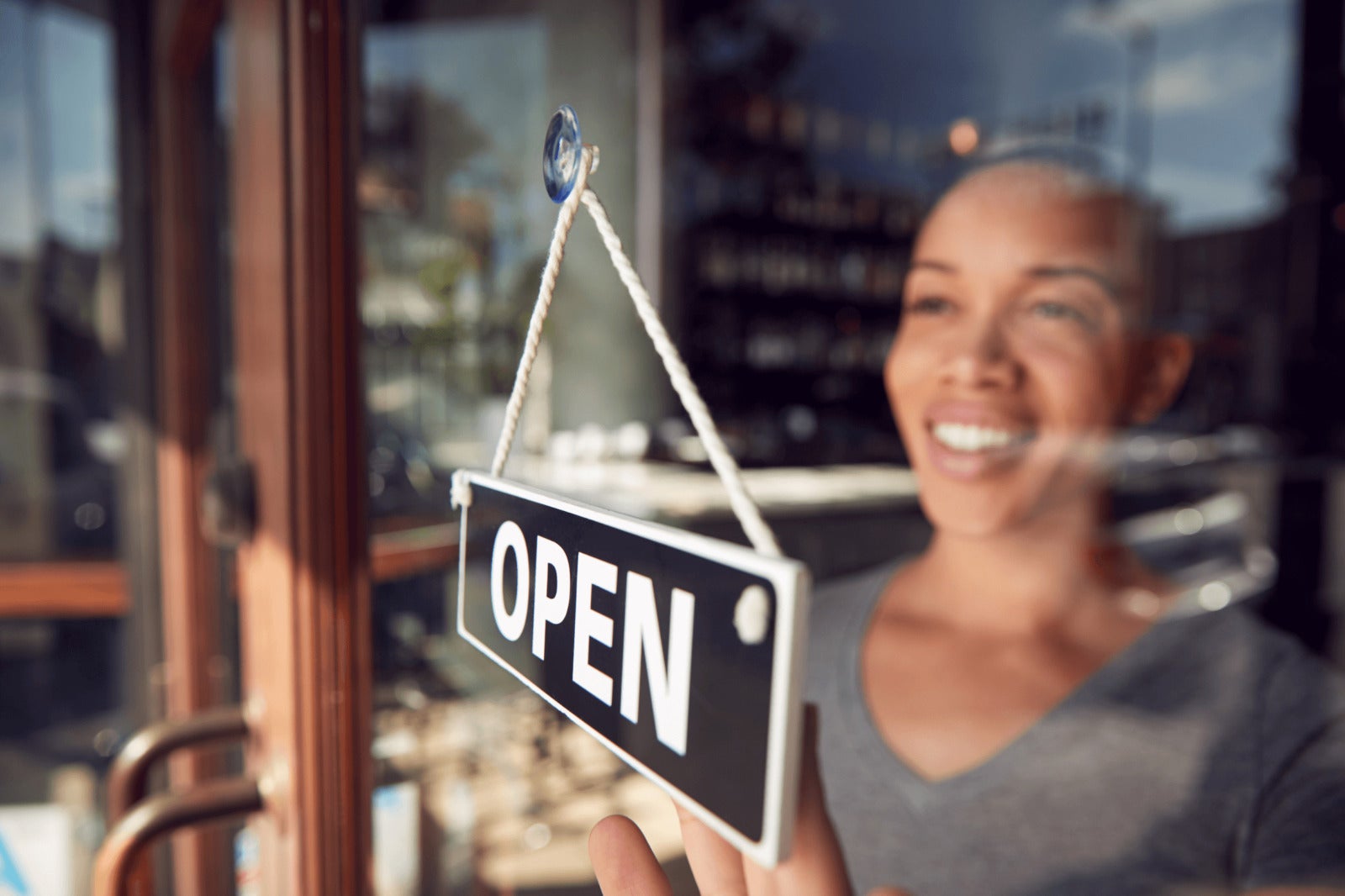 franchisee owner stands at door to open business