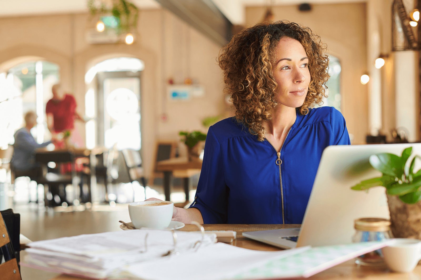 small business owner analyzes documents and works on laptop