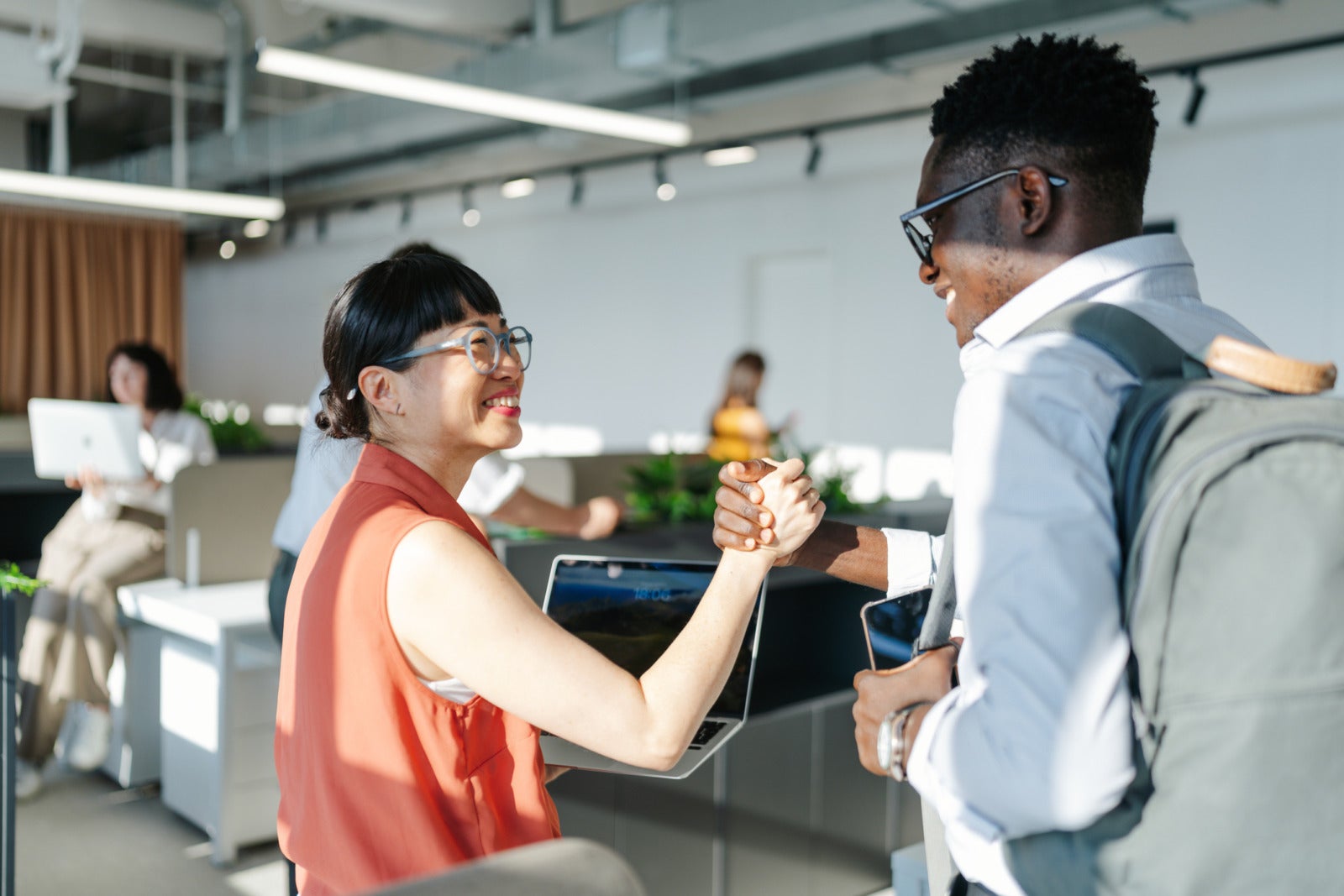 Photo of a couple of diverse people working in a co-working office space